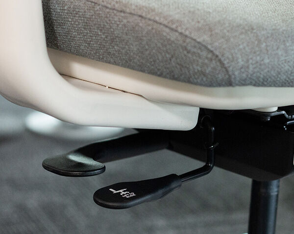 Close-up of Ascent chair lever beneath the seat for reclining or tilt adjustment.
